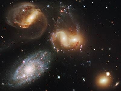 Stephan&#39;s Quintet includes four distant galaxies that are connected through gravity and one galaxy that is much closer to us but just happens to lie in the same direction in the sky.