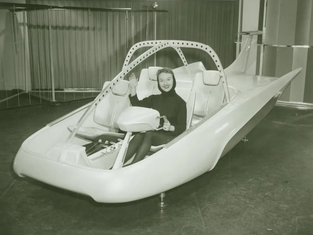 A woman poses in a full-scale model of the Studebaker-Packard Astral