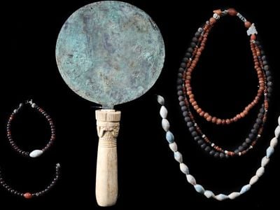 An engraved mirror and beaded jewelry discovered at the ancient family tomb near Luxor