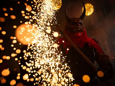 A participant dressed up as a demon brandishes a stick with fireworks during Correfoc in Catalonia.