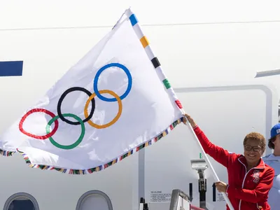 Los Angeles Mayor Karen Bass waves an Olympic flag on her return from the closing ceremony of the Paris games on August 12, 2024.