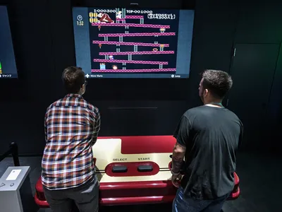 Guests play a throwback &quot;Donkey Kong&quot; game with an oversized controller at the Nintendo Museum.