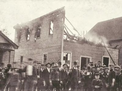 A white mob poses outside of the razed office of the&nbsp;Daily Record, a Black-owned newspaper in Wilmington, North Carolina, on November 10, 1898.