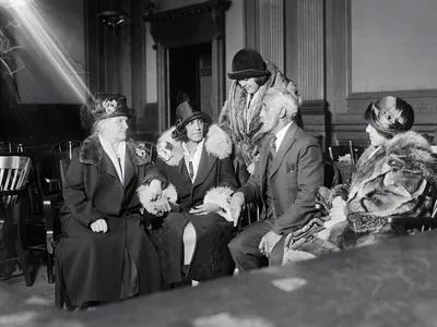 Alice Beatrice Rhinelander, n&eacute;e Jones (seated at center), looks at her father, George Jones, as they await the verdict in the&nbsp;Rhinelander v. Rhinelander&nbsp;case.